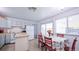 Kitchen and dining area with floral tablecloth, red chairs, and sliding glass doors to backyard at 2519 S Sable Way, Aurora, CO 80014