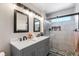 Bathroom boasts a double vanity, stylish mirrors, and a sleek glass-enclosed shower at 2010 E 125Th Pl, Thornton, CO 80241