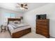 Well-lit bedroom is complete with a bed, side table, and dresser with a ceiling fan at 2010 E 125Th Pl, Thornton, CO 80241