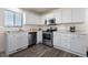 Bright kitchen features stainless steel appliances, white cabinets, and modern countertops at 2010 E 125Th Pl, Thornton, CO 80241