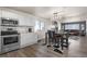 Bright kitchen featuring stainless steel appliances, white cabinets, and an adjacent dining area at 2010 E 125Th Pl, Thornton, CO 80241