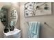 Stylish powder room with a modern vanity, decorative mirror, and elegant floral accents at 2010 E 125Th Pl, Thornton, CO 80241