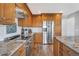 Well-equipped kitchen with stainless steel appliances, granite counters, and wood cabinets at 1625 Adobe Pl, Highlands Ranch, CO 80126