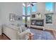 Sunlit living room featuring a fireplace, large windows, and hardwood floors at 1625 Adobe Pl, Highlands Ranch, CO 80126