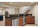 Basement wet bar with stainless steel appliances, granite countertop, and wood cabinetry at 15179 W Washburn Ave, Lakewood, CO 80228