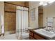 Well-lit bathroom featuring a shower with tile surround, vanity, and classic fixtures at 15179 W Washburn Ave, Lakewood, CO 80228