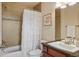 Bright bathroom featuring tile backsplash, white vanity, and shower-tub combo with curtain at 15179 W Washburn Ave, Lakewood, CO 80228