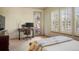 Bright bedroom featuring shutters, a work station, and access to an outdoor patio at 15179 W Washburn Ave, Lakewood, CO 80228
