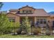 Charming home featuring a tile roof, manicured landscaping, and a black metal fence at 15179 W Washburn Ave, Lakewood, CO 80228