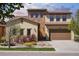 Charming two-story home featuring a stone facade and a well-manicured front yard with colorful landscaping at 15179 W Washburn Ave, Lakewood, CO 80228