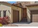 Charming home exterior featuring a three-car garage, stone accents, and a beautifully stained wooden door at 15179 W Washburn Ave, Lakewood, CO 80228