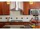 Elegant kitchen with stainless steel appliances, pendant lighting, and tile backsplash at 15179 W Washburn Ave, Lakewood, CO 80228