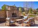 Charming outdoor stone fireplace surrounded by comfortable seating, creating the perfect setting for relaxation at 15179 W Washburn Ave, Lakewood, CO 80228