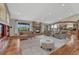 Open living room with a stone fireplace, hardwood floors, and view into the kitchen at 2094 Lost Canyon Ranch Ct, Castle Rock, CO 80104