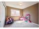 Cozy bedroom with soft carpet, a bright window, and playful decor at 11093 Nome St, Commerce City, CO 80640