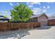 View of home's exterior from the side of the home with wooden fencing and a detached garage at 11093 Nome St, Commerce City, CO 80640