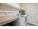 Functional laundry room with modern washer and dryer, plus storage and a folding area at 11093 Nome St, Commerce City, CO 80640