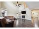 Spacious living room with hardwood floors, vaulted ceilings, fireplace, and abundant natural light from large windows at 11093 Nome St, Commerce City, CO 80640