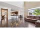 Open-concept living room with hardwood floors, a sofa, and a view to the kitchen area at 11093 Nome St, Commerce City, CO 80640