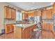 Modern kitchen featuring an island with seating, stainless steel appliances, stone backsplash, and wood cabinets at 6761 Mary Ct, Castle Pines, CO 80108