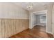 Dining room featuring wood paneled wall and hardwood floors, open to another room at 770 Havana St, Aurora, CO 80010
