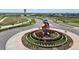 Aerial view of roundabout art and landscaped median with new home construction in the background at 3453 N Gold Bug Ct, Aurora, CO 80019