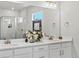 Elegant bathroom featuring double sinks, modern fixtures, decorative flowers, and a glass-enclosed shower at 3453 N Gold Bug Ct, Aurora, CO 80019