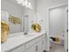 Bright bathroom featuring a double vanity, large mirror, and a separate toilet and shower area at 3453 N Gold Bug Ct, Aurora, CO 80019
