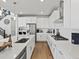 Modern kitchen features white cabinets, stainless steel appliances, quartz countertops, and hardwood floors at 3453 N Gold Bug Ct, Aurora, CO 80019