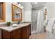 Bathroom with a vanity, marble tiled shower, and warm wooden accents at 30264 Upper Bear Creek Rd, Evergreen, CO 80439