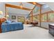 Bright bedroom boasts exposed wooden beams and large windows overlooking the surrounding forest at 30264 Upper Bear Creek Rd, Evergreen, CO 80439