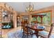 Charming dining room with rustic chandelier, wood accents, and a view of outdoor scenery from the covered porch at 30264 Upper Bear Creek Rd, Evergreen, CO 80439