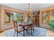Cozy dining area with wood-paneled walls, antler chandelier, and large picture windows with treetop views at 30264 Upper Bear Creek Rd, Evergreen, CO 80439