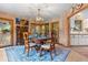 Inviting dining space with wood accents, unique lighting, and scenic views from surrounding windows and doors at 30264 Upper Bear Creek Rd, Evergreen, CO 80439