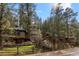 Exterior view of house with partial car garage, stone fence and mountain trees at 30264 Upper Bear Creek Rd, Evergreen, CO 80439