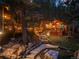 Charming log cabin home with stone walkway, wooden decks, and beautiful outdoor lighting at 30264 Upper Bear Creek Rd, Evergreen, CO 80439