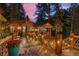 Cabin exterior featuring a wooden deck with decorative railings and string lights at twilight at 30264 Upper Bear Creek Rd, Evergreen, CO 80439