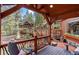 Charming exterior featuring a spacious deck, rustic railings, and natural stone accents, set in a wooded landscape at 30264 Upper Bear Creek Rd, Evergreen, CO 80439