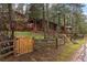 Charming log cabin nestled among trees with a fenced yard and winding driveway at 30264 Upper Bear Creek Rd, Evergreen, CO 80439