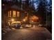 Exterior of home at night, showing the car garage and extra cabin building at 30264 Upper Bear Creek Rd, Evergreen, CO 80439