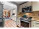 Kitchen with stainless steel appliances, white cabinets, terracotta floors, and open view to the dining room at 30264 Upper Bear Creek Rd, Evergreen, CO 80439