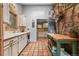 Quaint kitchen with stone accents, tile flooring, white cabinets, and an undermount sink beneath a window at 30264 Upper Bear Creek Rd, Evergreen, CO 80439