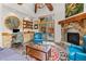 Inviting living room featuring a stone fireplace, built-in shelving, and access to a deck with forest views at 30264 Upper Bear Creek Rd, Evergreen, CO 80439