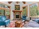 Bright, stylish living room featuring a stone fireplace, comfortable seating, and large windows with scenic views at 30264 Upper Bear Creek Rd, Evergreen, CO 80439