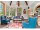 Bright living room with vaulted ceilings, exposed beams, large windows, and stylish decor with mountain views at 30264 Upper Bear Creek Rd, Evergreen, CO 80439