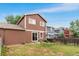 This home has a backyard with green grass and a mix of trees and fencing for added privacy at 5168 Goshawk St, Brighton, CO 80601
