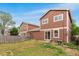 This home has a backyard with green grass and a mix of trees and fencing for added privacy at 5168 Goshawk St, Brighton, CO 80601