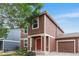 Attractive two-story home with brown siding, front garden and attached garage at 5168 Goshawk St, Brighton, CO 80601
