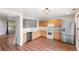 Modern kitchen boasts wood cabinets, stainless steel appliances, and stylish wood floors at 5168 Goshawk St, Brighton, CO 80601