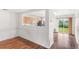 Open-concept living room with wood floors, light walls, and kitchen view at 5168 Goshawk St, Brighton, CO 80601